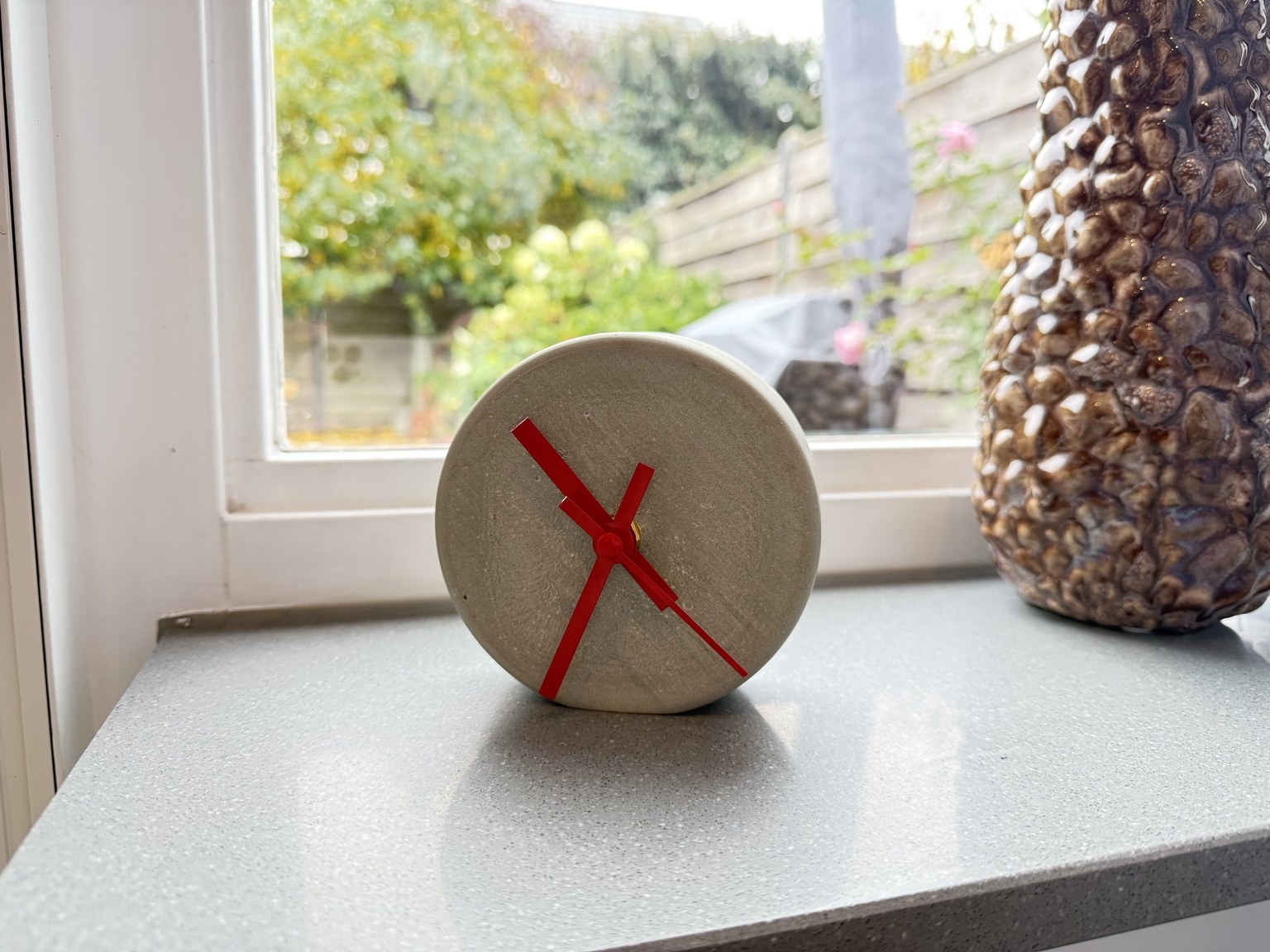 Betonklokje van schuin opzij, met de structuur van het beton in beeld